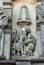 Belur, Karnataka, India - November 2, 2013: Chennakeshava Temple. Gray Wall Stone Panel Sculpture Of Lord Vishnu Surrouned By His Two Consorts Devi Lakshmi And Devi Bhu. Side Of Temple.