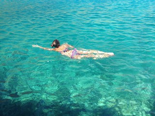 young woman swimming in clear blue water