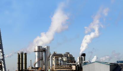 Thick plumes of smoke billowing from factory chimneys.