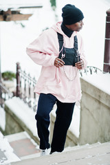 Wall Mural - Stylish urban style african american man in pink hoodie posed at winter day.