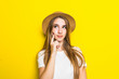 © dianagrytsku - Young woman posing touching chin with smile on yellow background.