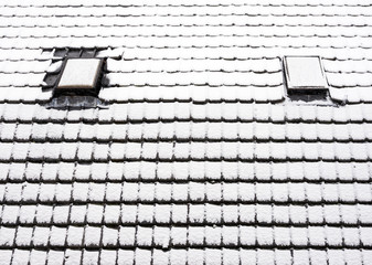 snow covered roof tiles of house in winter