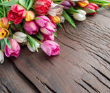 Fototapeta Tulipany - Colorful  bouquet of tulips on old wooden background.