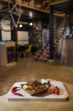 Fototapeta  - Small pork chops with fries on a wooden board with fresh vegetables