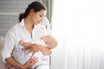 baby sleeping on the mother's chest. young mother cuddling baby