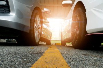 Two cars on beside front prepare for race with yellow line in center.