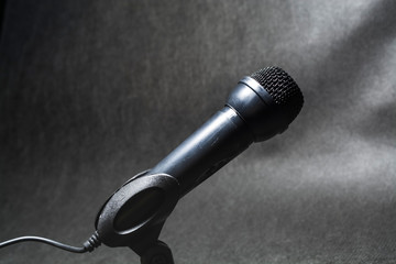 The electric microphone on a monophonic black background. Equipment for the singer or blogger. Music. Technologies.