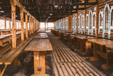 Fototapeta Mosty linowy / wiszący - An empty indoor flea market with wooden numbered tables and benches in the Izmailovo Kremlin