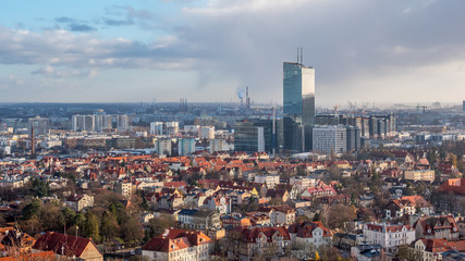 Aerial view of Gdansk, town in Poland, red roofs of old houses, commercial modern building in the back with beautiful cloudy sky in the background