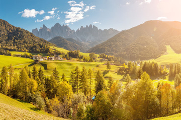  Famous travel destination in Italian Dolomites Funes valley. Val Di Funes and Santa Magdalena village during autumn with rocky Alps at the background