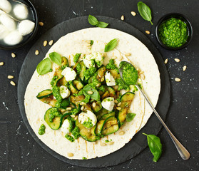 Wall Mural - Grilled zucchini, mozzarella and pesto salad on a tortilla cake. Snack. Selective focus.