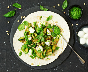 Wall Mural - Grilled zucchini, mozzarella and pesto salad on a tortilla cake. Snack. Selective focus.