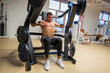 © Yakov - Athlete does deltoid exercises on hammer machine