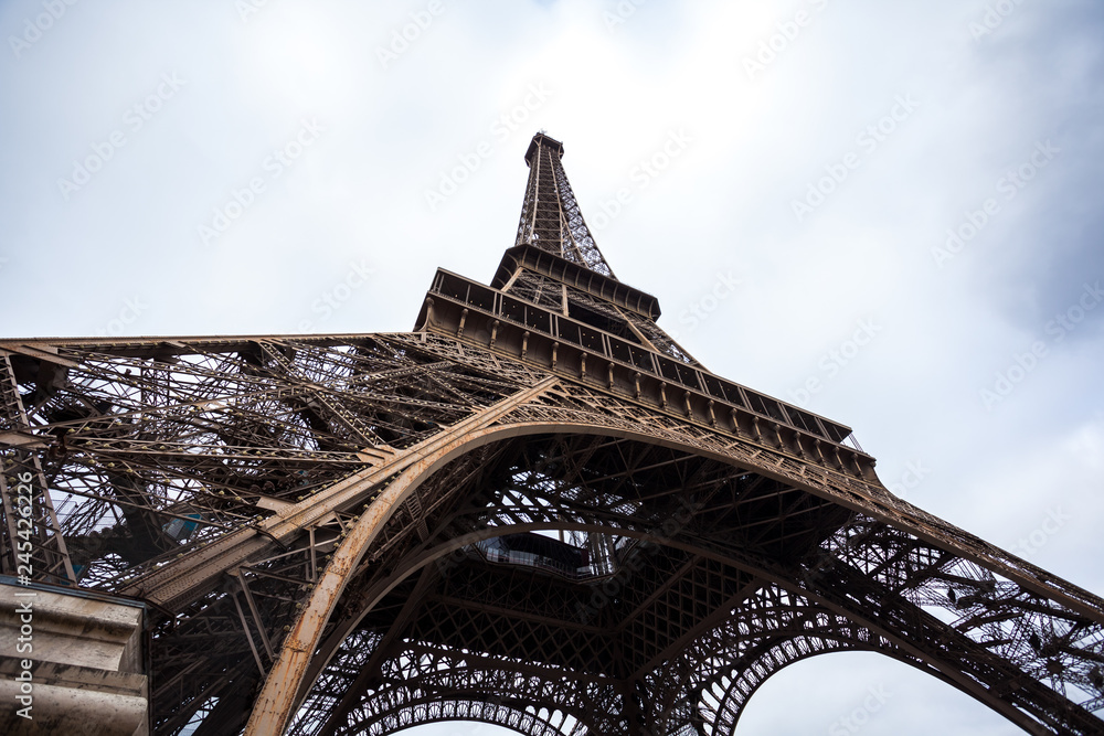 The Eiffel Tower in Paris shot against the sky - obrazy, fototapety, plakaty 