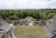 View from top of a Mayan temple, looking down at other Mayan buildings and the surrounding jungle