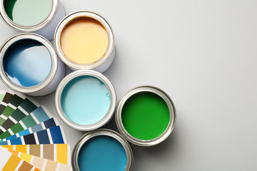 Paint cans and color palette on white background, top view. Space for text