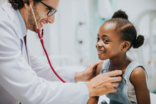 Friendly Pediatrician Checking A Little Girls Heart