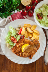 Wall Mural - Breaded viennese schnitzel with baked potatoes