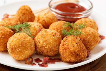 Potato croquettes - mashed potatoes balls breaded and deep fried, served with different sauce.