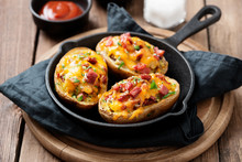 Hot Baked Potato Topped With Bacon, Green Onions And Cheddar Cheese.