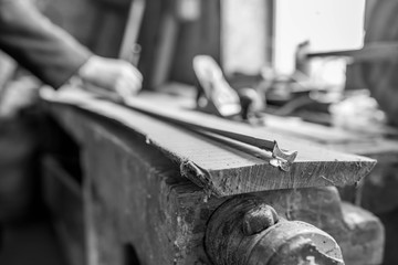 Wall Mural - Carpenter measuring a long oak board, focus on the ruler, shallow depth of field, in black and white.