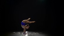 Gymnast Stands On The Hands Performs Acrobatic Movements. Black Background. Slow Motion