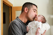 © javiindy - Father kissing his newborn baby girl.