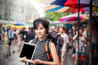 © kittipong - Young happy asian woman tourist in market shopping with tablet computer for online map.Traveling backpacker girl present screen of digital tablet outdoor .Travel tourism,technology concept. copy space