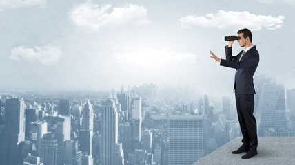 Wall Mural - businessman looking forward to a city with binoculars from skyscraper concept
