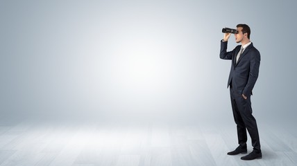 Wall Mural - businessman looking forward with binoculars in an empty space