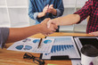 © Ngampol - Finishing up a meeting, handshake of two happy business people after contract agreement to become a partner, collaborative teamwork