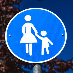 Information sign for a footpath for pedestrians only, symbolized by a figure with skirt and a child figure, not gender correct