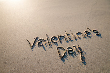 Valentine's Day message handwritten on a tropical beach with smooth sand copy space