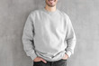 © Damir Khabirov - Mock up shot of young man body in empty sweatshirt isolated on textured gray wall background. No face photo