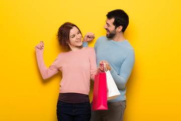 Wall Mural - Couple in valentine day holding shopping bags in victory position