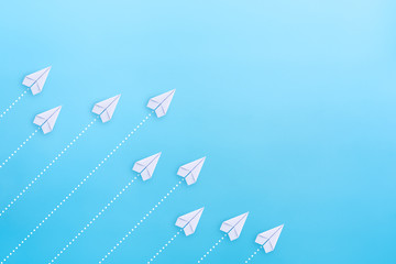 Wall Mural - White paper planes on blue background. Business competition concept.