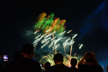 Crowd watching fireworks and celebrating city founded. Beautiful colorful fireworks display in the urban for celebration on dark night background.