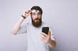 © Vulp - Bearded man using smartphone scared in shock with surprised face with fear expression