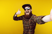 Like ! Bearded Guy Taking Selfie In Black Hat And Sunglasses And Gesturing Thumb Up, Good, Like Symbol
