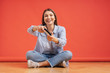 © arthurhidden - Excited casual young woman playing video games having fun on red background