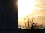Fototapeta  - osiedle na obrzeżach miasta, zachodzące słońce za blokiem 