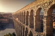 Perspective view of the roman aqueduct of the city of Segovia, next to some houses of the urban center, Segovia, Spain