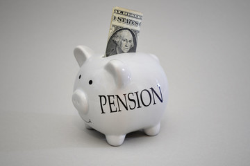 piggy bank with dollar money with text pension on the gray backgroud