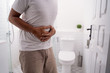 © Odua Images - man hold his stomach painful in the toilet