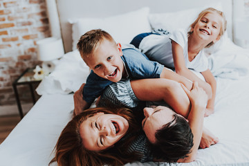 Joyful man and woman having fun with kids