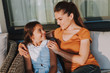 © Yakobchuk Olena - Positive loving mother resting with her daughter at home