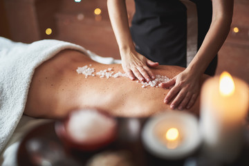 Wall Mural - Therapist apply mineral salt on lady back