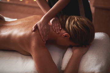 Lady having stress relieving massage in spa salon