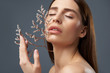 © Yakobchuk Olena - Gorgeous brunette girl holding beautiful sprigs with white flowers near her face
