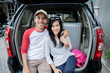 © Odua Images - couple sitting on a car's trunk smiling together